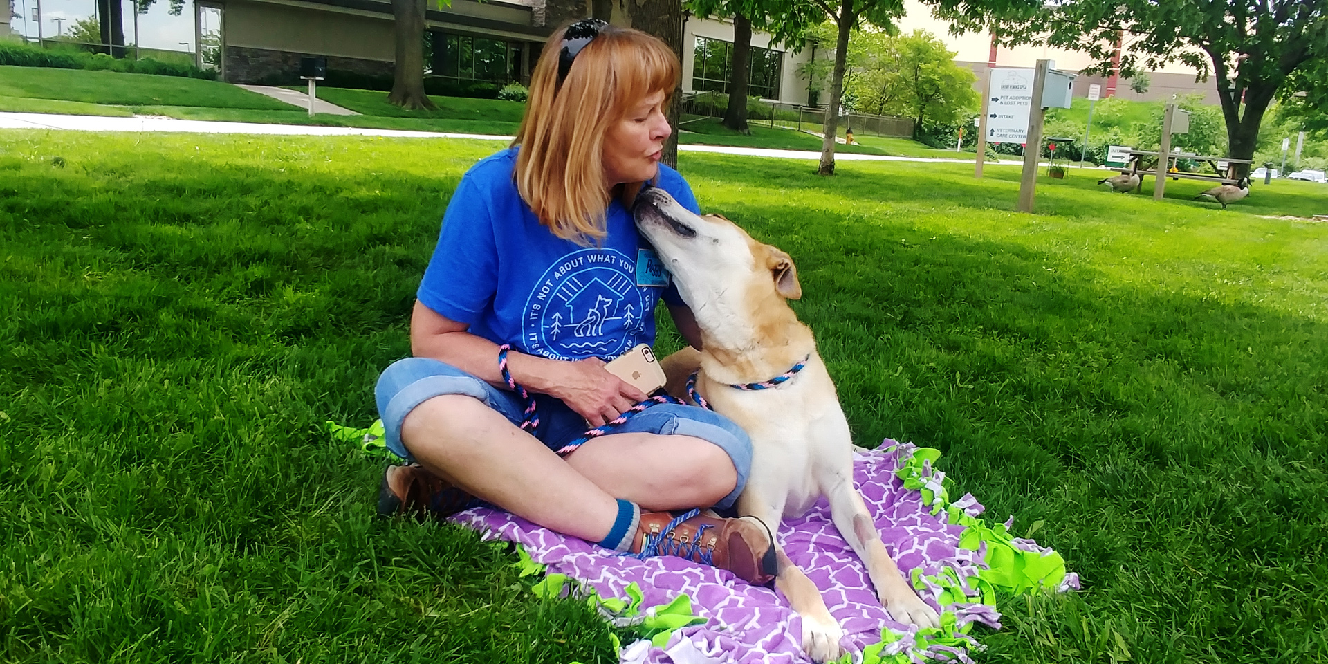 Woman sits on blanket with dog